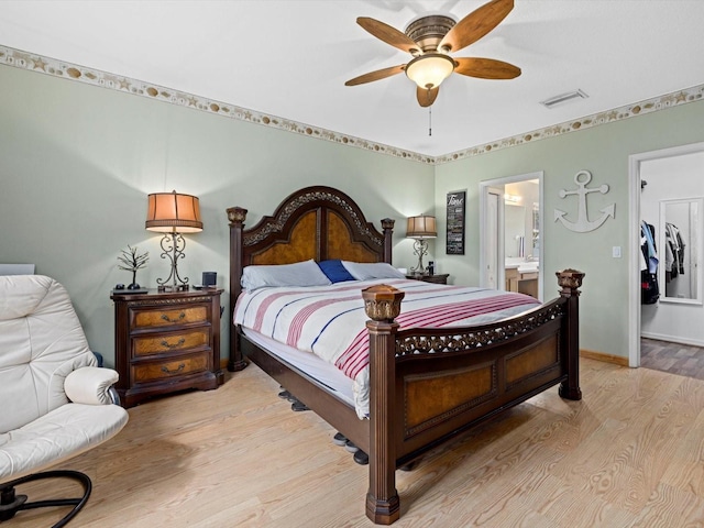 8222 Haven Harbour Way, Bradenton, FL 34212 - bedroom with light wood-style flooring, a spacious closet, ensuite bath, ceiling fan, and baseboards