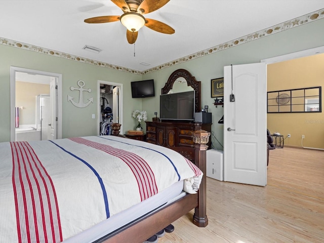 8222 Haven Harbour Way, Bradenton, FL 34212 - bedroom featuring light wood-style floors, a walk in closet, ensuite bathroom, and ceiling fan