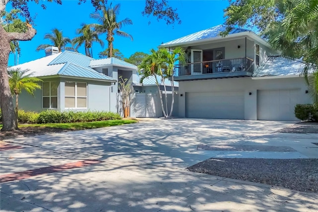4505 Camino Real, Sarasota, FL 34231 - view of front of property featuring a balcony, concrete driveway, stucco siding, and metal roof