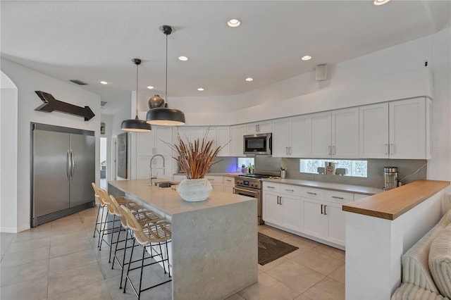4505 Camino Real, Sarasota, FL 34231 - kitchen featuring premium appliances, a sink, light tile patterned floors, a breakfast bar, and arched walkways