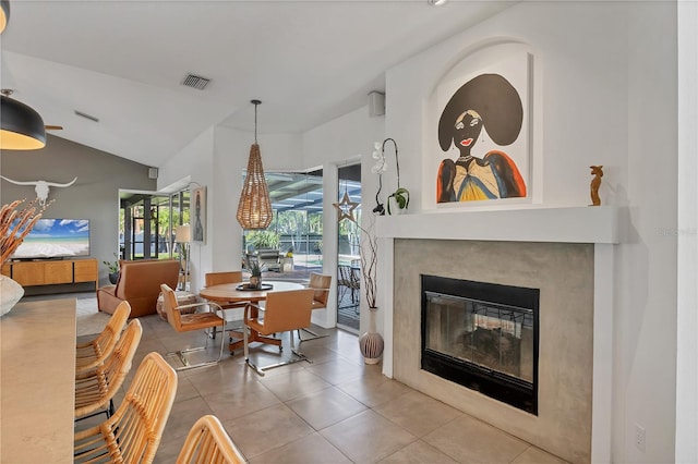 4505 Camino Real, Sarasota, FL 34231 - dining room featuring a glass covered fireplace, tile patterned floors, and lofted ceiling