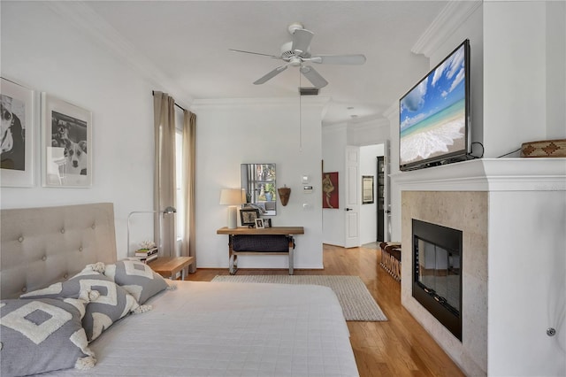 4505 Camino Real, Sarasota, FL 34231 - bedroom featuring crown molding, light wood finished floors, a glass covered fireplace, and ceiling fan