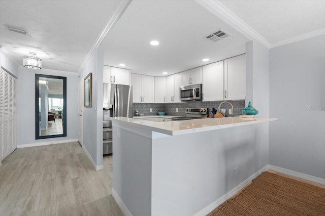 1255 E Peppertree Dr Unit 507, Sarasota, FL 34242 - kitchen with appliances with stainless steel finishes, ornamental molding, decorative backsplash, light countertops, and white cabinets