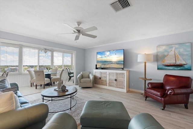 1255 E Peppertree Dr Unit 507, Sarasota, FL 34242 - living area featuring light wood-style flooring, a ceiling fan, crown molding, baseboards, and a textured ceiling