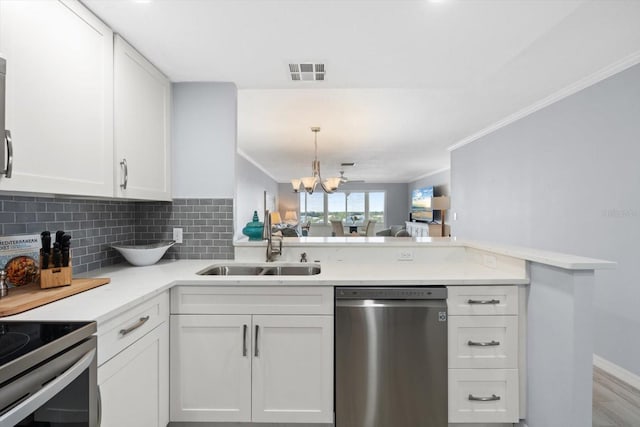 1255 E Peppertree Dr Unit 507, Sarasota, FL 34242 - kitchen featuring stainless steel appliances, a sink, white cabinets, tasteful backsplash, and light countertops