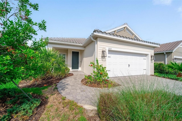 2625 Star Apple Way, Sarasota, FL 34240 - single story home featuring a tiled roof, driveway, an attached garage, and stucco siding