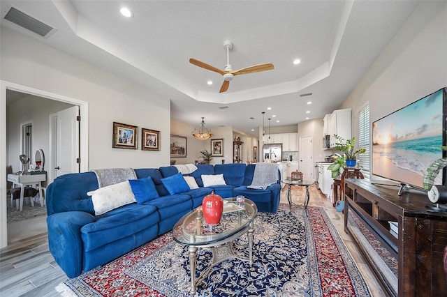 2625 Star Apple Way, Sarasota, FL 34240 - living area with a tray ceiling, ceiling fan, recessed lighting, and light wood-style floors
