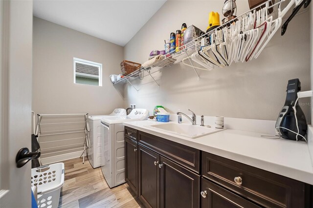 2625 Star Apple Way, Sarasota, FL 34240 - laundry room featuring separate washer and dryer, cabinet space, and light wood-type flooring