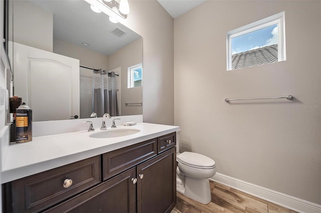 2625 Star Apple Way, Sarasota, FL 34240 - full bathroom with wood finished floors, vanity, toilet, baseboards, and a shower with curtain