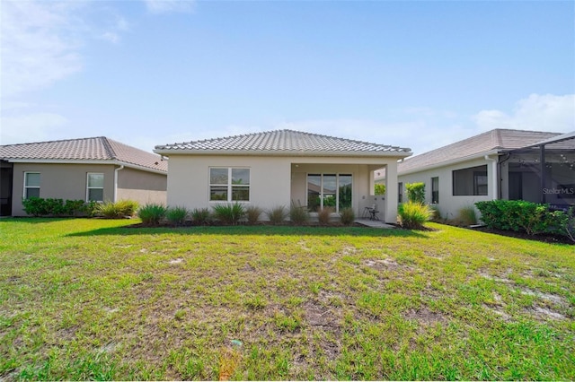 2625 Star Apple Way, Sarasota, FL 34240 - rear view of house with stucco siding, a lawn, and a tile roof