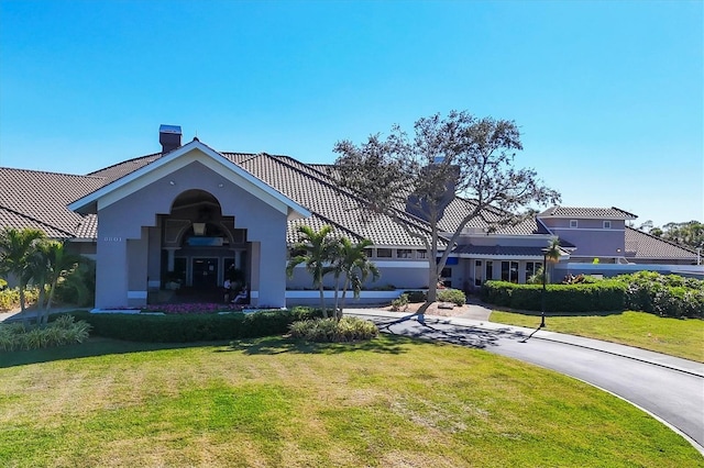 9630 Club S Cir Unit 6303, Sarasota, FL 34238 - view of front of house featuring stucco siding, a front yard, a tiled roof, and a chimney