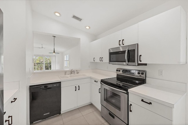 9630 Club S Cir Unit 6303, Sarasota, FL 34238 - kitchen with stainless steel appliances, a sink, white cabinetry, light countertops, and light tile patterned floors