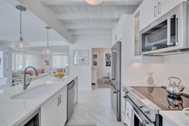 643 Calle Del Otono, Sarasota, FL 34242 - kitchen with appliances with stainless steel finishes, a sink, white cabinetry, decorative light fixtures, and glass insert cabinets