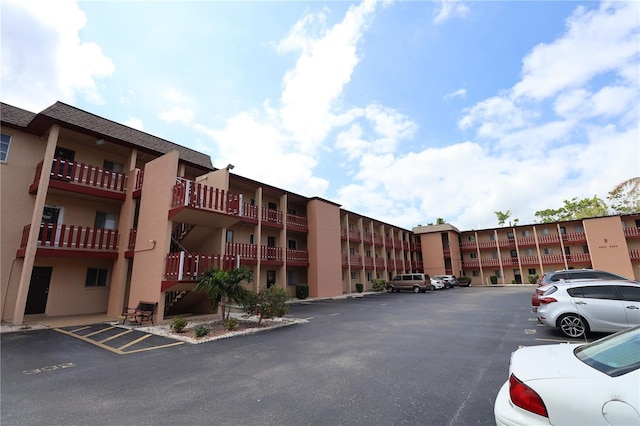 view of apartment building / complex featuring uncovered parking