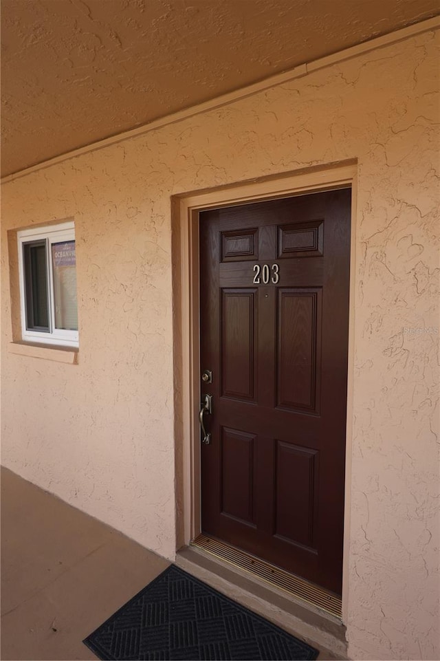 doorway to property with stucco siding
