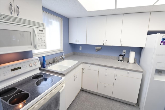 kitchen with white appliances, a sink, light countertops, and white cabinetry
