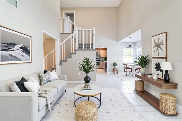 5310 SW 25th Ct, Cape Coral, FL 33914 - living area featuring a towering ceiling, stairway, light tile patterned floors, and baseboards