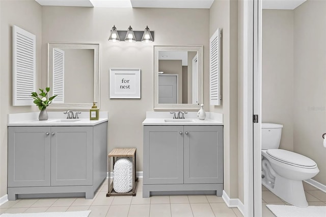 5310 SW 25th Ct, Cape Coral, FL 33914 - bathroom featuring two vanities, toilet, tile patterned floors, and baseboards