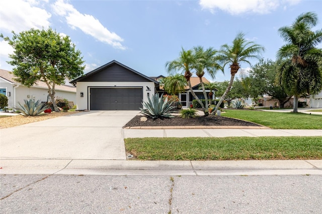 11021 4th Ave E, Bradenton, FL 34212 - view of front of home featuring an attached garage, driveway, a front lawn, and stucco siding