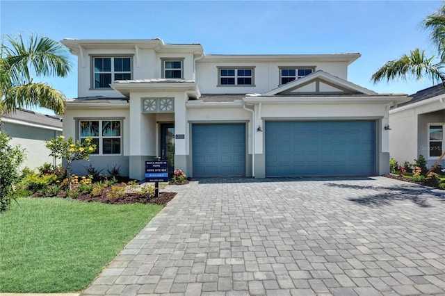 17723 Palmiste Dr, Bradenton, FL 34202 - view of front of house with stucco siding, decorative driveway, a front lawn, and an attached garage