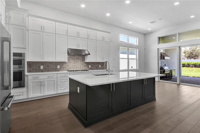 17723 Palmiste Dr, Bradenton, FL 34202 - kitchen with dark wood-type flooring, under cabinet range hood, plenty of natural light, white cabinets, and recessed lighting