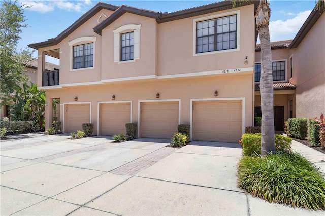 4220 Via Piedra Cir Unit 4-101, Sarasota, FL 34233 - view of property with stucco siding, a tiled roof, driveway, and an attached garage