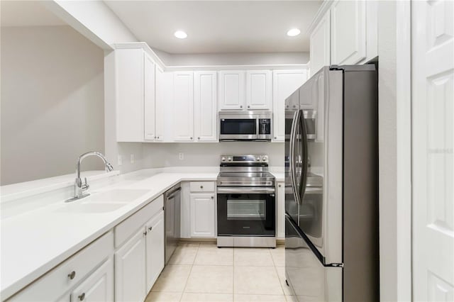 4220 Via Piedra Cir Unit 4-101, Sarasota, FL 34233 - kitchen with stainless steel appliances, a sink, light tile patterned floors, white cabinets, and light countertops