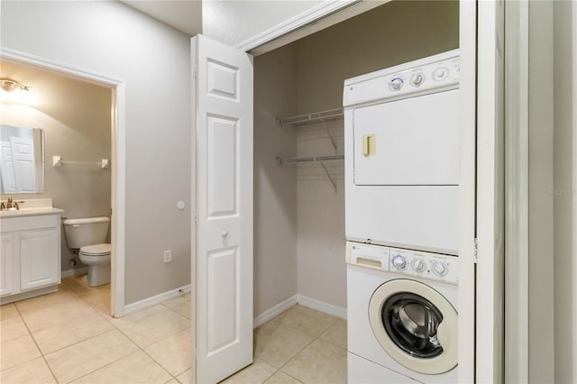 4220 Via Piedra Cir Unit 4-101, Sarasota, FL 34233 - laundry room with stacked washer and clothes dryer, light tile patterned floors, and baseboards