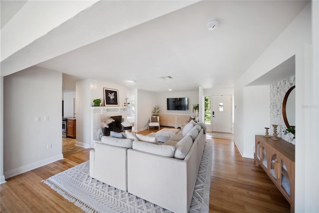 3810 Hidden River Rd, Sarasota, FL 34240 - living area with a fireplace, light wood finished floors, and baseboards