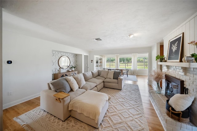 3810 Hidden River Rd, Sarasota, FL 34240 - living room with baseboards, light wood-type flooring, and a brick fireplace