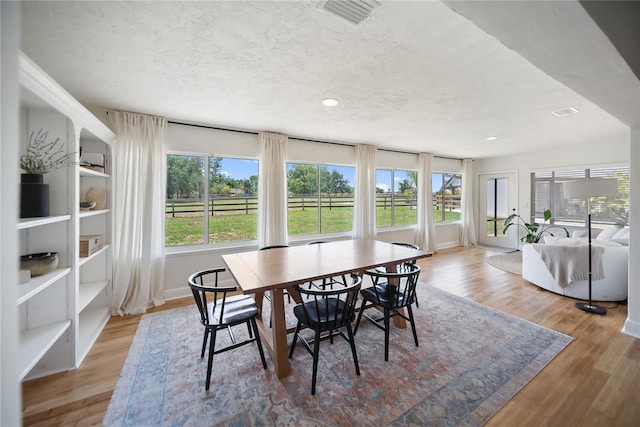 3810 Hidden River Rd, Sarasota, FL 34240 - dining room with wood finished floors, recessed lighting, a textured ceiling, and baseboards
