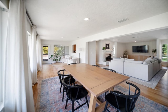 3810 Hidden River Rd, Sarasota, FL 34240 - dining space with wood finished floors, healthy amount of natural light, a fireplace, recessed lighting, and a textured ceiling