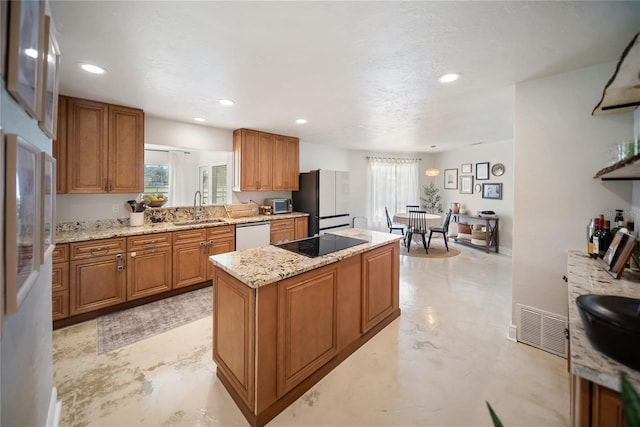 3810 Hidden River Rd, Sarasota, FL 34240 - kitchen featuring freestanding refrigerator, a sink, brown cabinetry, a kitchen island, and recessed lighting