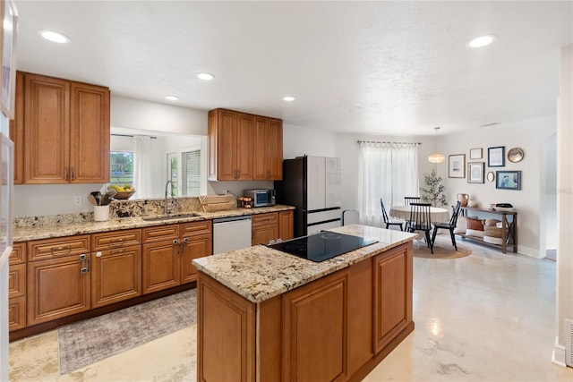 3810 Hidden River Rd, Sarasota, FL 34240 - kitchen with dishwashing machine, brown cabinetry, a sink, black electric stovetop, and a kitchen island