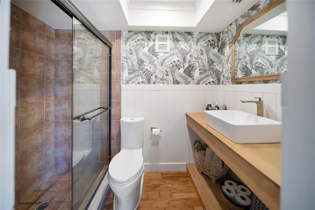 3810 Hidden River Rd, Sarasota, FL 34240 - bathroom with a sink, wood finished floors, a stall shower, toilet, and a wainscoted wall