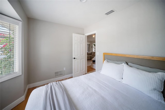 3810 Hidden River Rd, Sarasota, FL 34240 - bedroom with multiple windows, baseboards, and wood finished floors