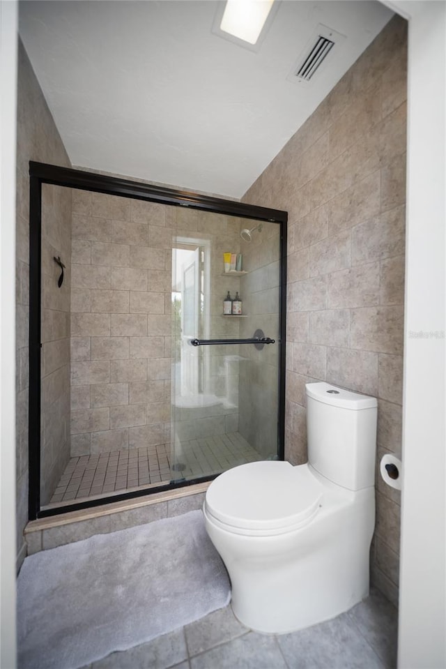 3810 Hidden River Rd, Sarasota, FL 34240 - bathroom with tile walls, toilet, a stall shower, tile patterned flooring, and lofted ceiling