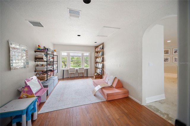 3810 Hidden River Rd, Sarasota, FL 34240 - sitting room featuring arched walkways, wood finished floors, and baseboards