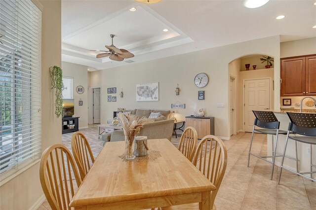 12358 Lavender Loop, Bradenton, FL 34212 - dining space featuring arched walkways, ceiling fan, light tile patterned flooring, baseboards, and a raised ceiling