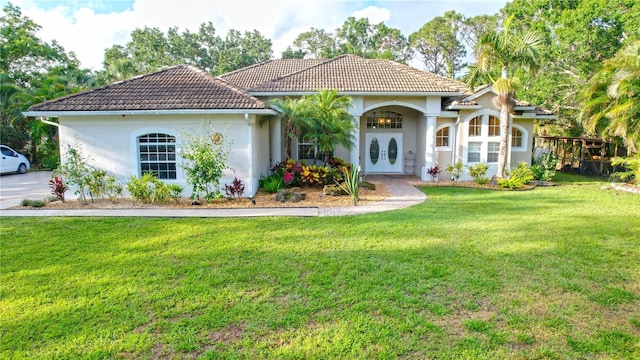 950 Trotter St, Nokomis, FL 34275 - mediterranean / spanish house with a front lawn, a tile roof, and stucco siding