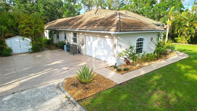 950 Trotter St, Nokomis, FL 34275 - view of front of house featuring a tile roof, central AC unit, concrete driveway, stucco siding, and an attached garage