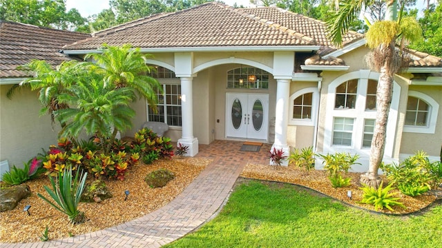 950 Trotter St, Nokomis, FL 34275 - view of exterior entry featuring stucco siding and a tile roof