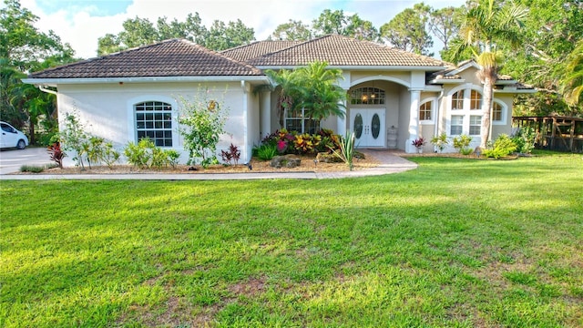 950 Trotter St, Nokomis, FL 34275 - mediterranean / spanish home with a tiled roof, a front yard, stucco siding, and french doors