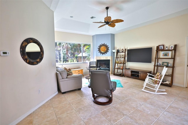 950 Trotter St, Nokomis, FL 34275 - living area featuring a raised ceiling, light tile patterned floors, a tile fireplace, a ceiling fan, and baseboards