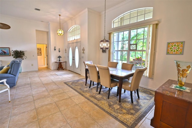 950 Trotter St, Nokomis, FL 34275 - dining space featuring crown molding, healthy amount of natural light, light tile patterned flooring, a towering ceiling, and a chandelier