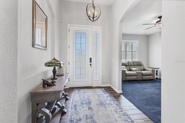12755 Rainwashed Loop, Parrish, FL 34219 - entrance foyer with arched walkways, a ceiling fan, a chandelier, wood finished floors, and baseboards