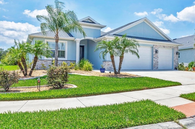 12755 Rainwashed Loop, Parrish, FL 34219 - ranch-style home with driveway, an attached garage, stone siding, a front lawn, and stucco siding