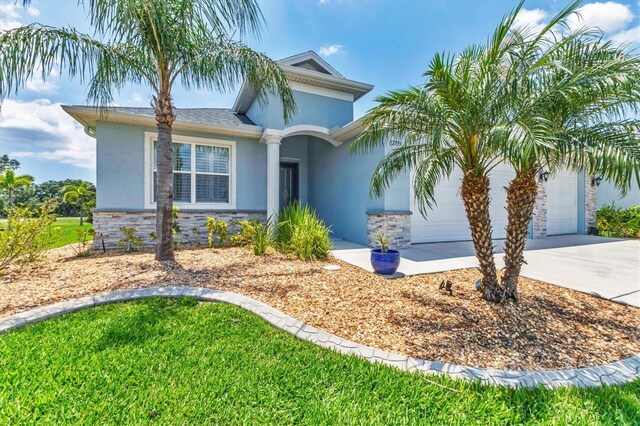 12755 Rainwashed Loop, Parrish, FL 34219 - view of front of property featuring stucco siding, stone siding, driveway, and an attached garage