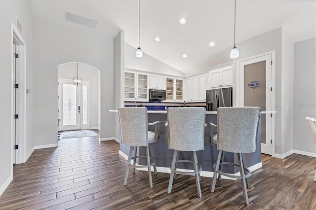 12755 Rainwashed Loop, Parrish, FL 34219 - kitchen with appliances with stainless steel finishes, arched walkways, white cabinetry, glass insert cabinets, and lofted ceiling