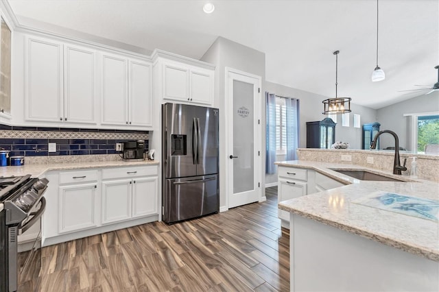 12755 Rainwashed Loop, Parrish, FL 34219 - kitchen featuring stainless steel refrigerator with ice dispenser, a sink, black range with gas cooktop, vaulted ceiling, and white cabinetry